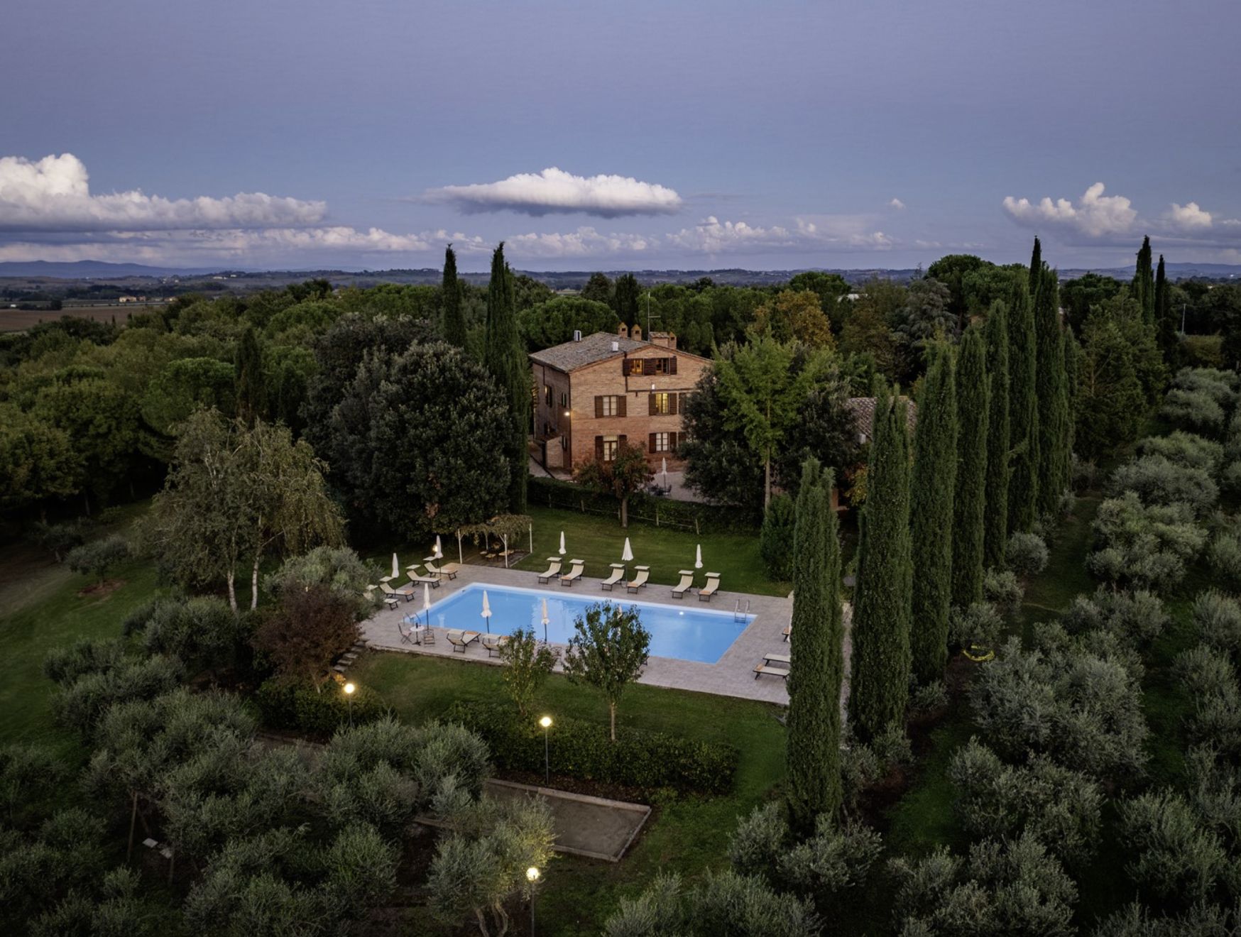 La villa illuminée à la tombée de la nuit