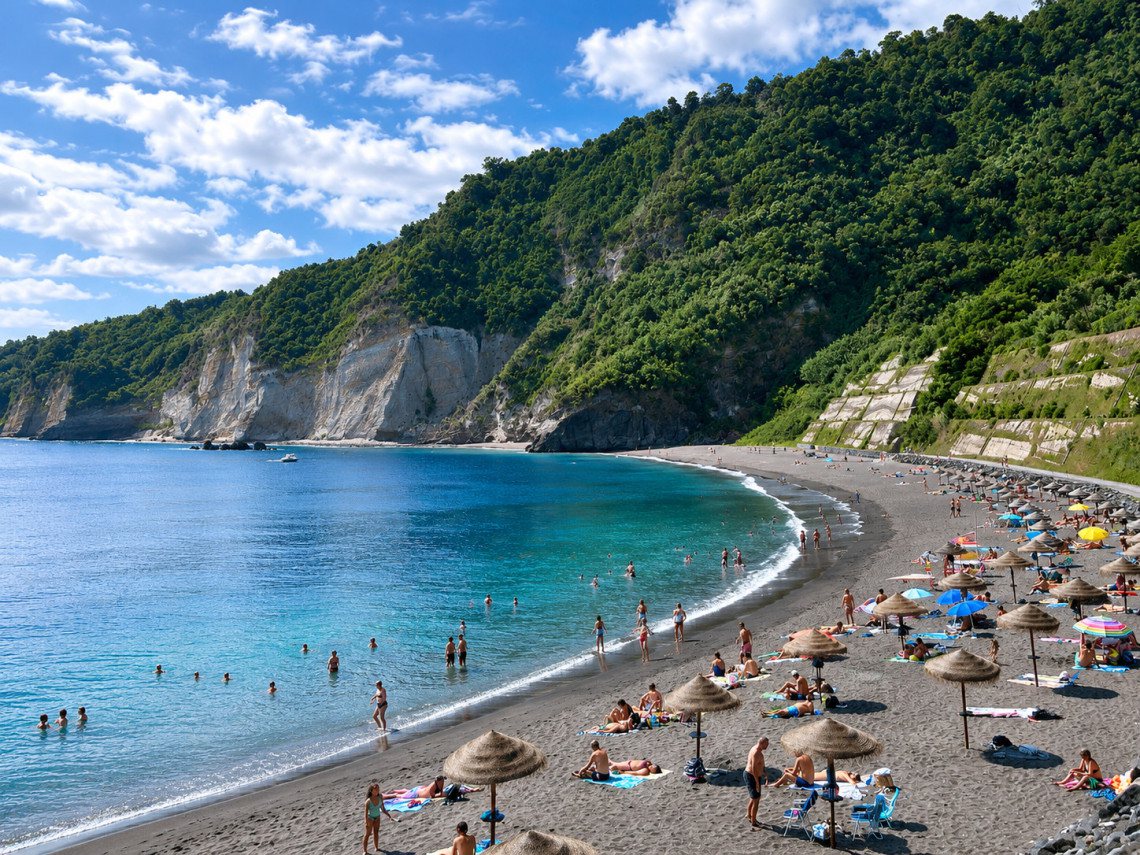 Une plage de sable noir au pied des falaises