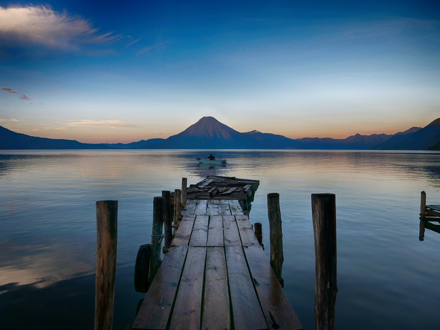 Ponton sur le lac Atitlán face au volcan au crépuscule