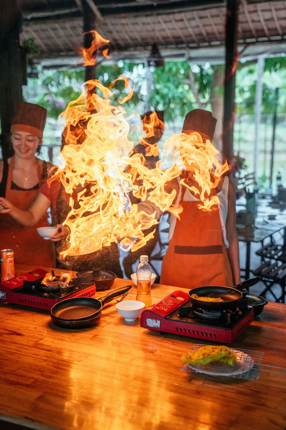 Le groupe en tabliers autour d'une poêle qui flambe
