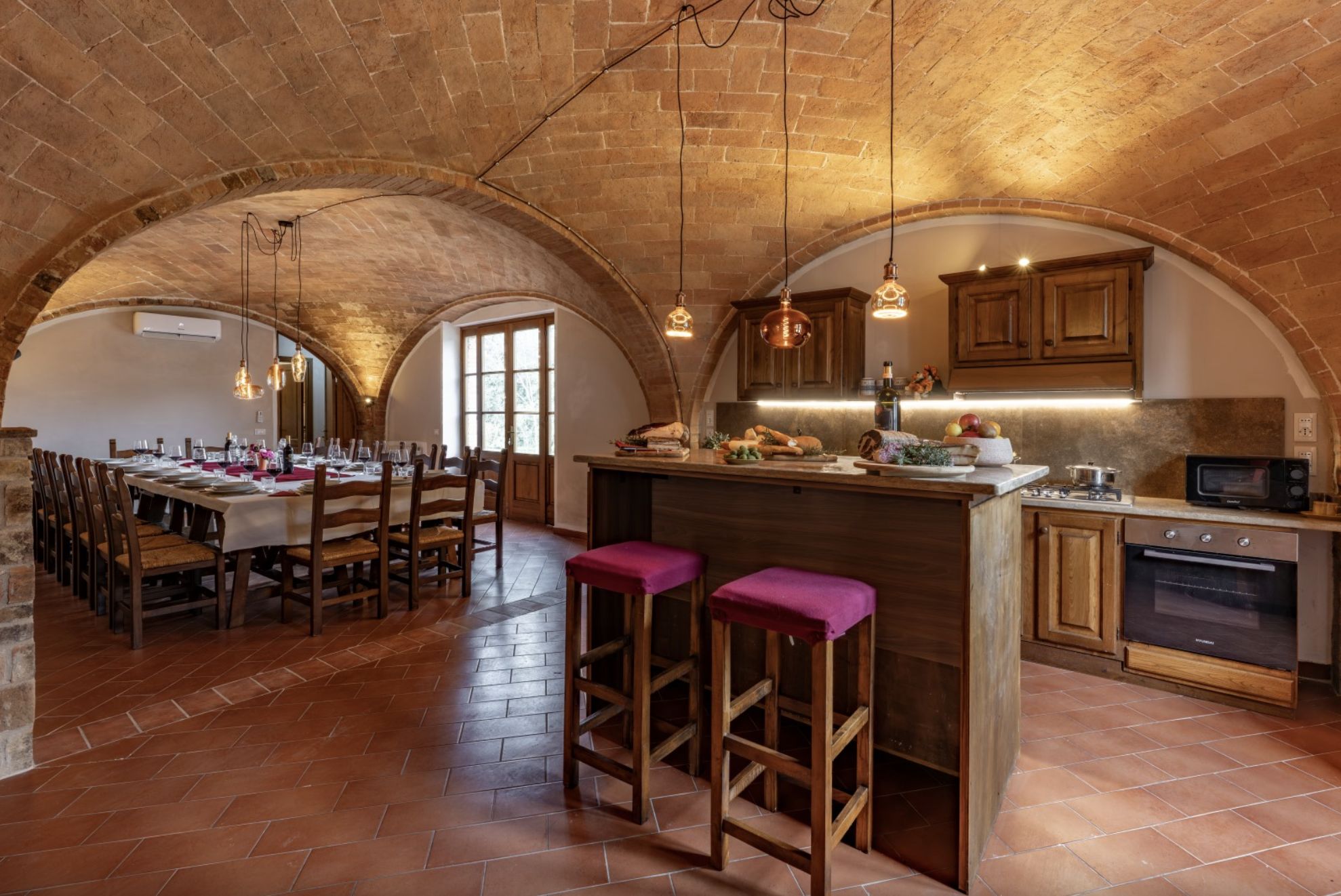 La cuisine de la villa et la grande table dressée sous les voûtes de briques
